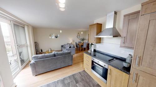 a kitchen and living room with a couch and a table at Lovely Furnished Apartment 2 in Carlisle