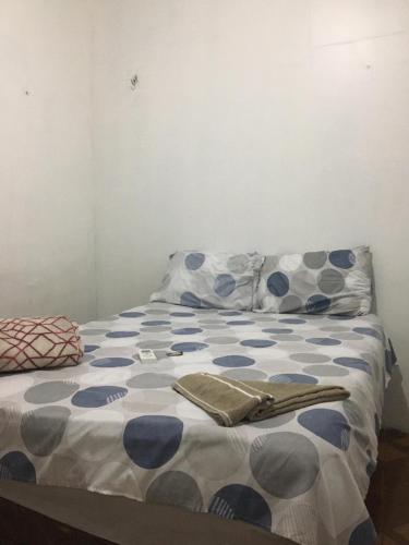 a bed with blue and white sheets and pillows at Casa Aconchegante na praça 14 in Manaus