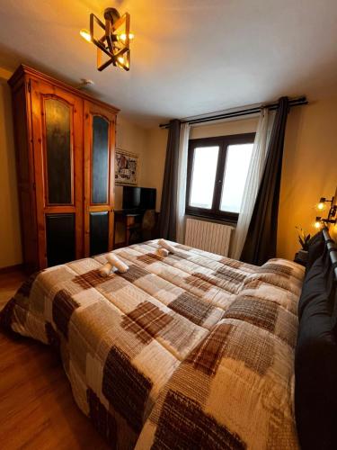a bedroom with a large bed and a window at Hotel Genevris Cinq in Sauze d'Oulx