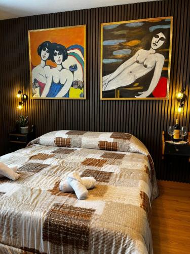 a bedroom with a bed with two pictures on the wall at Hotel Genevris Cinq in Sauze d'Oulx