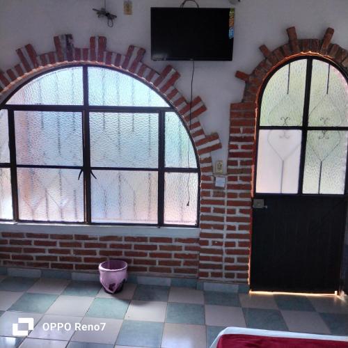 an empty room with two windows and a door at Hotel San Jose Purua in Vidalrstn