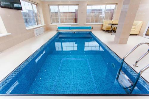 a large swimming pool with blue water in a building at Apartment baku in Baku