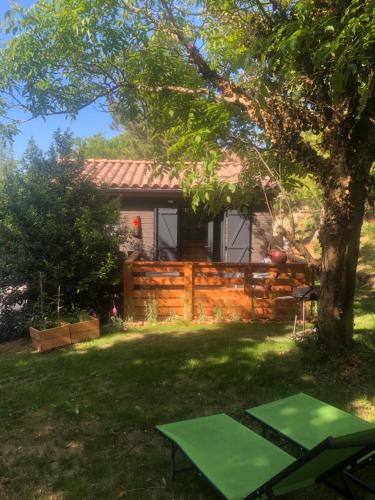 a cottage with a tree in the yard at Le Chalet in Fanjeaux