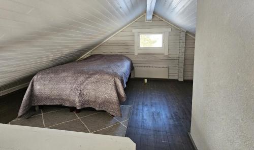 Habitación con cama en un ático con ventana en Villa Tuliniemi, en Siilinjärvi