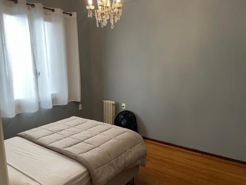 a bedroom with a bed and a chandelier at Excepcional apartamento Art Deco de 3 dormitorios in Montevideo