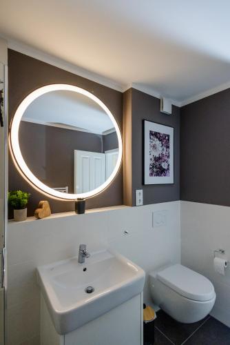 a bathroom with a white sink and a mirror at UNiQE I Luxuriöses 145qm Apartment in Feldafing