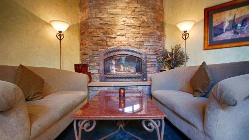 a living room with two couches and a fireplace at SFO El Rancho Inn SureStay Collection by Best Western in Millbrae