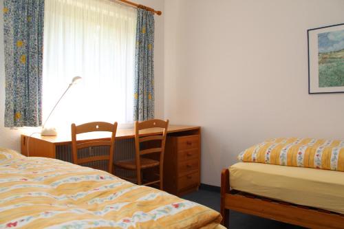 ein Schlafzimmer mit Bett, Schreibtisch und Fenster in der Unterkunft Apartment Eisenhauer in Schluchsee in Schluchsee