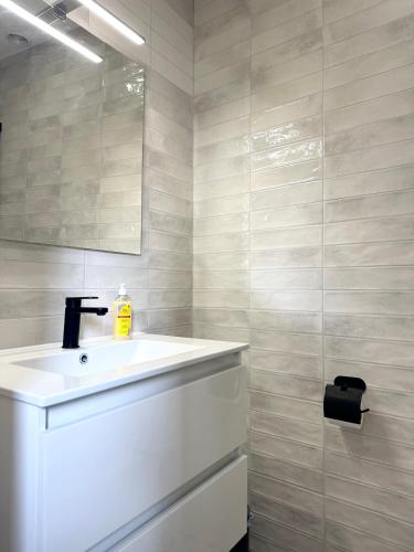 a bathroom with a white sink and a mirror at Mercat Suites in Valencia