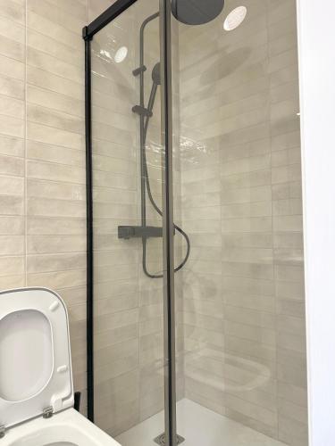 a bathroom with a glass shower with a toilet at Mercat Suites in Valencia