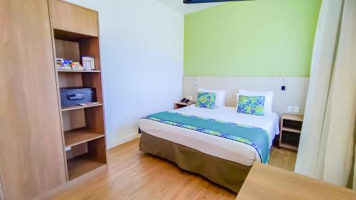a bedroom with a bed and a book shelf at Blue Tree Towers Valinhos in Valinhos