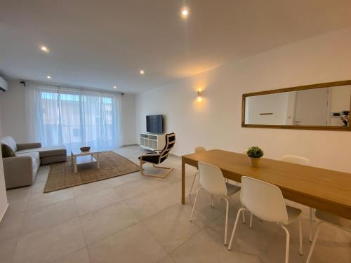 a living room with a dining table and a living room with a couch at Swieqi Malaika New Apt 5 in Is-Swieqi