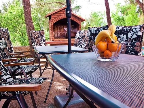 a table with a bowl of oranges and a basket of bananas at Apartments Paklenica in Starigrad