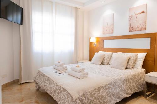 a bedroom with a large bed with towels on it at Mandarina 119 in San Miguel de Abona