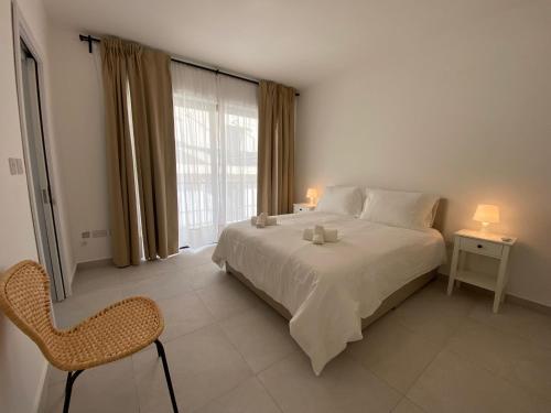 Is-SwieqiにあるSwieqi Malaika New Apt 8のベッドと椅子と窓のある寝室