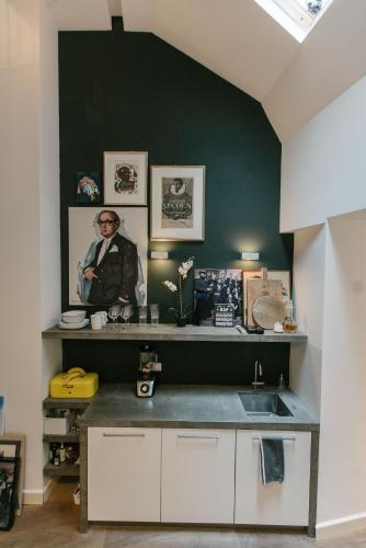 a kitchen with a sink and a green wall at Spui apartment in center in Amsterdam