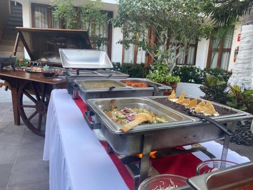 a buffet of food is set up on a table at Hotel Boutique La Pergola in Manzanillo