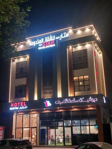 a hotel with a sign on the front of it at night at شقق ستار القمة للشقق المخدومة in Al Hofuf