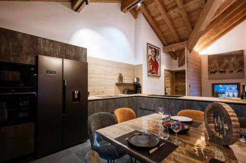 une cuisine avec une table et un réfrigérateur dans l'établissement Chalet Le Cervin - Chalet en triplex 14 personnes 5 exposé Sud-Est MAE-7551, à Valloire