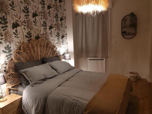 a bedroom with a large bed with a chandelier at Ker gwelanig in Trégastel