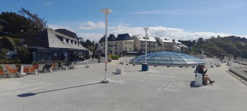 a woman walking down a street with a building at Ker gwelanig in Trégastel