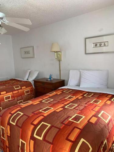 a bedroom with a bed with a colorful blanket at Sunshine Motel in Wildwood