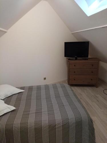 une chambre avec un lit et une télévision à écran plat dans l'établissement Maison neuve 2 chambres, à Chambly