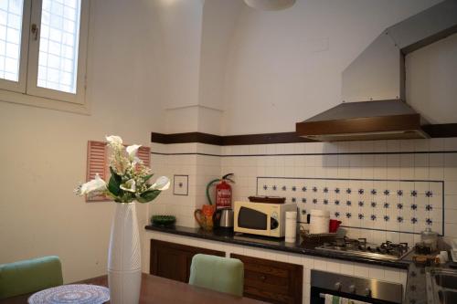 a kitchen with a table with a vase of flowers at Mary Apt - Historical Residence- Lecce in Lecce