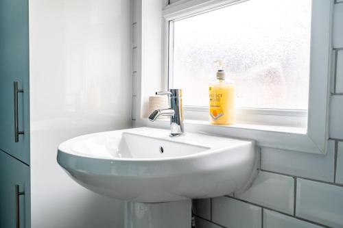 a white sink in a bathroom with a window at Edinburgh Street House 3 Bed, 4 Guest in Goole
