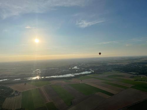 a hot air balloon flying in the sky over a field at La Petite Maison de la rue Fontaine Saint-Fursy in Péronne