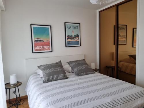 une chambre avec un lit avec deux oreillers dessus dans l'établissement Face à la mer en première ligne pour 6 personnes avec Ménage Linge et Wifi, à Arcachon