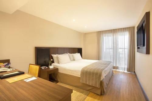 a hotel room with a bed and a desk at Luxury Place Hotel and Apartments in Jidu