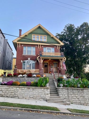 a red brick house with a porch and flowers at The Edmond an 1887 Arts & Crafts gem in Saint Joseph