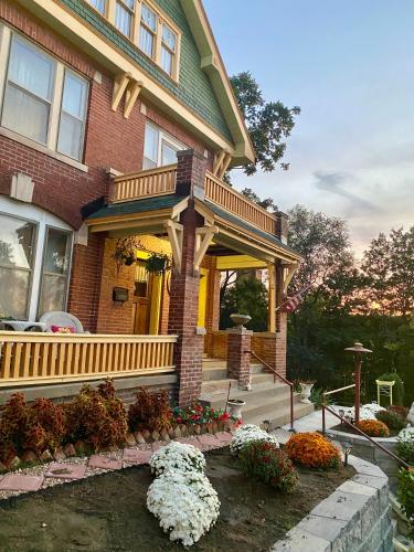 a house with a porch and flowers in front of it at The Edmond an 1887 Arts & Crafts gem in Saint Joseph