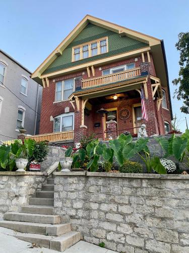 a red brick house with a stone retaining wall at The Edmond an 1887 Arts & Crafts gem in Saint Joseph