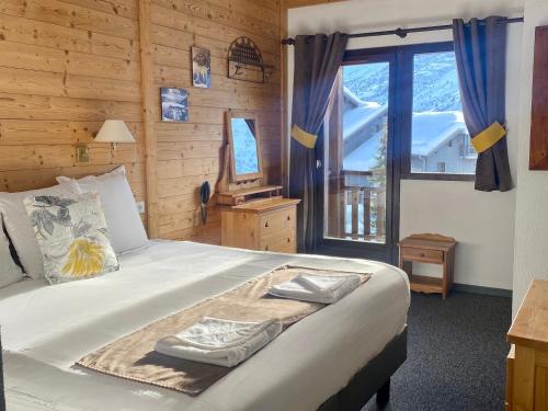 a bedroom with a bed and a window in a room at Hôtel Club "Les Carrettes" in Valmeinier