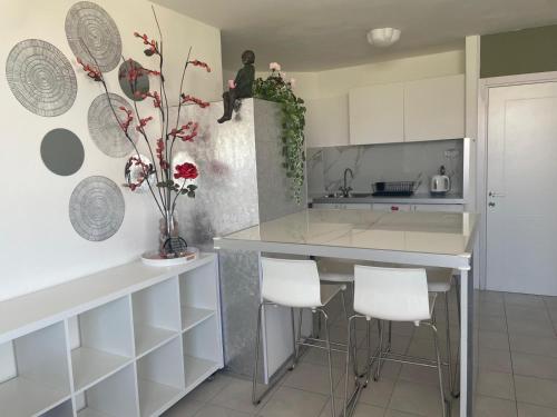 een keuken met witte kasten en een aanrecht met krukken bij 123Eilat tzofit in Eilat