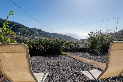 two chairs sitting on top of a hill with a view at Casa Morena - Private Tropical Oasis in Campanário