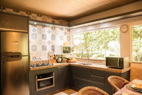 eine Küche mit Spüle und Fenster in der Unterkunft Sitio Cantinho da Vovó Cida e Vovô Nilson in São João Batista