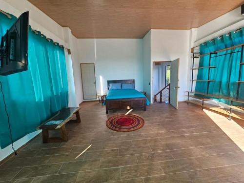 Un dormitorio con una cama y un televisor en una habitación. en Wayo ocean view Tamanique house, en Tamanique