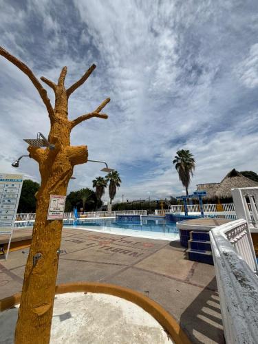 a wooden tree next to a swimming pool at Condominio San Esteban - Flandes Tolima in Flandes