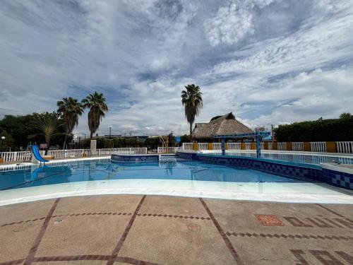 a large swimming pool with palm trees in the background at Condominio San Esteban - Flandes Tolima in Flandes
