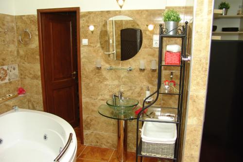 a bathroom with a tub and a table and a sink at Romantic Centrum Apartman in Budapest