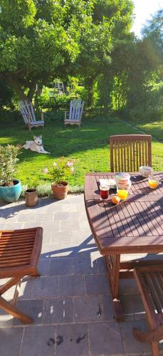 a wooden picnic table and chairs in a yard at Chambre Privée chez Guillaume in Bertry