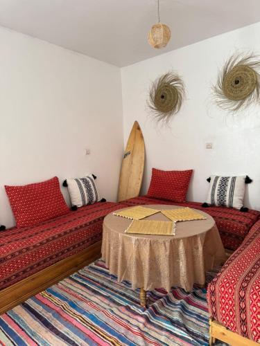 a room with a bed and a surfboard on the wall at La Porte sur l'océan in Sidi Kaouki