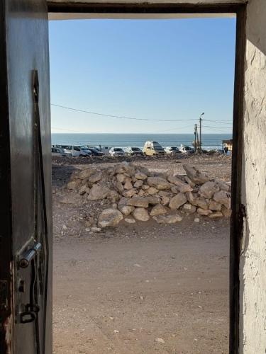 a door to a window with a view of the ocean at La Porte sur l'océan in Sidi Kaouki