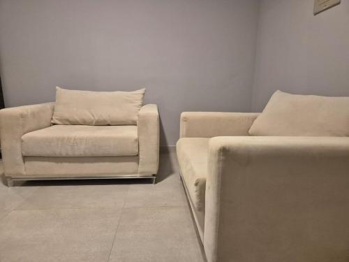 a living room with a couch and a chair at Fabuloso AP em Sete Lagoas in Sete Lagoas
