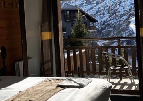 a bed in a room with a view of a mountain at Hôtel Club "Les Carrettes" in Valmeinier