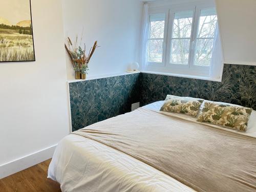 une chambre avec un grand lit avec une fenêtre dans l'établissement La cabane moderne, à Falaise