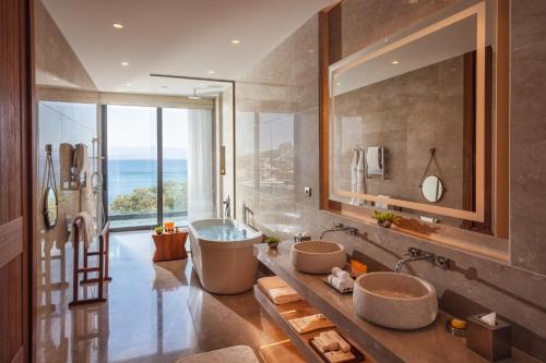 a bathroom with two sinks and a bath tub at Mandarin Oriental, Bodrum in Golturkbuku